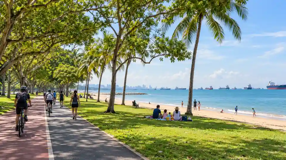Cyclists and families beside the beach at East Coast Park in Singapore